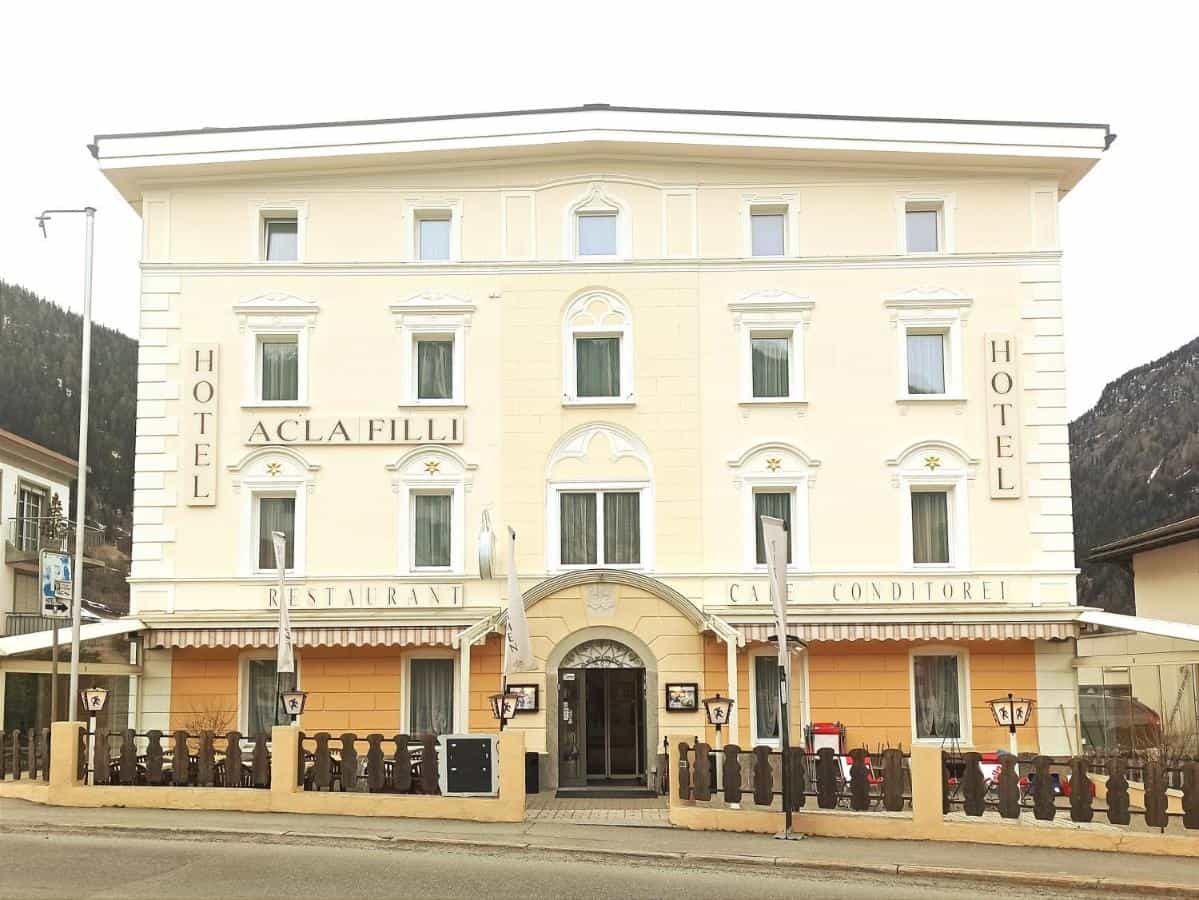 Hotel Acla Fili building with restaurant and cafe, set against a mountain backdrop in Zernez.