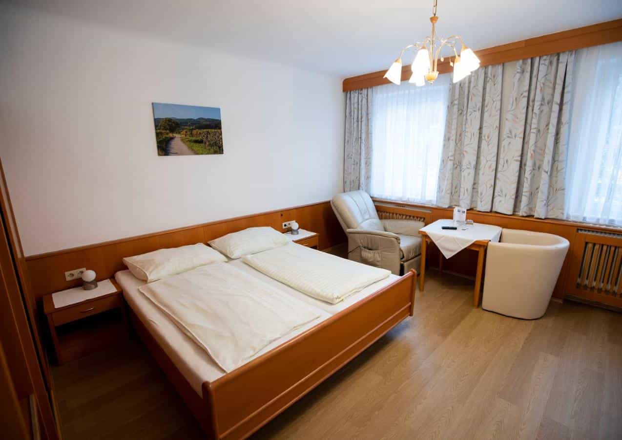 Hotel room at Hotel Gasthof Martinek Baden bei Wien with wooden bed and seating area