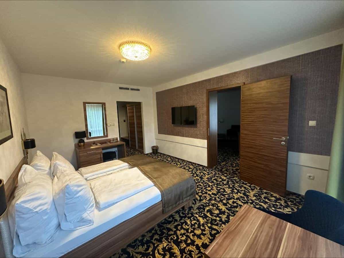 Superior hotel room with large bed, ornate carpet, and dark wood accents at Simbad Hotel & Bar.
