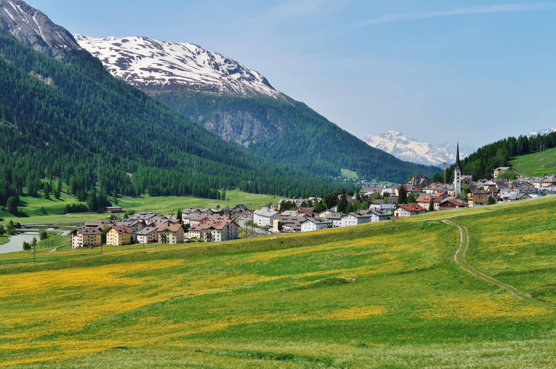 Alpine village of Bergdorf Zuoz in Graubünden, Switzerland, with snow-capped mountains.