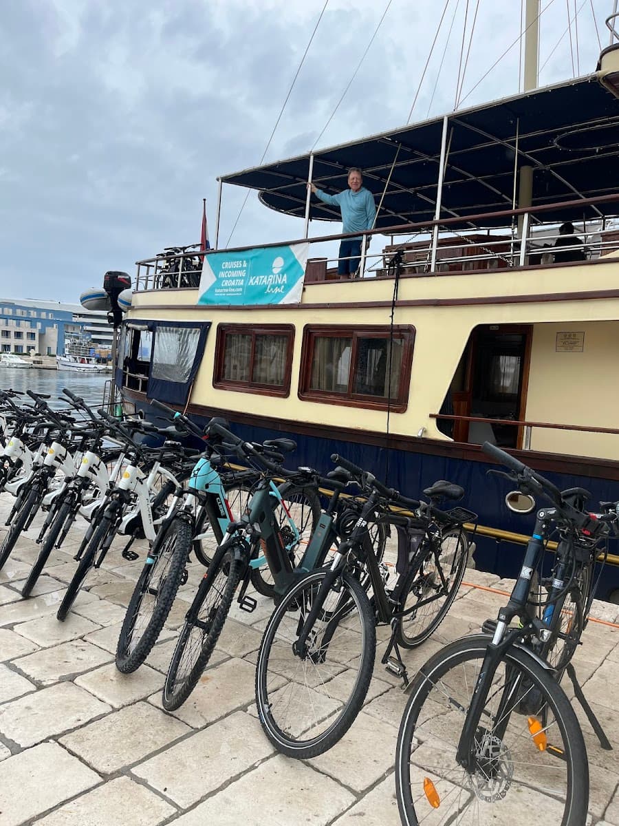 Bicycles parked on stone pier next to Katarina Line cruise boat in harbor