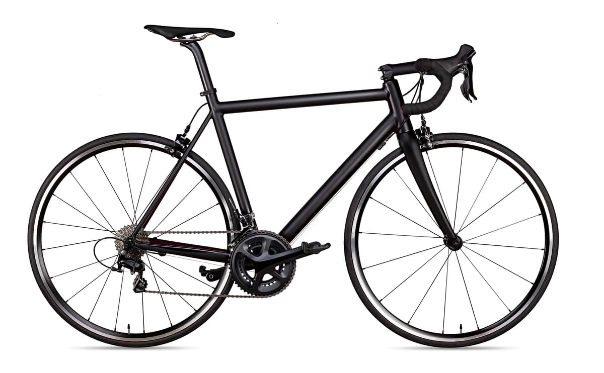 Black road bike with drop handlebars isolated on a white background