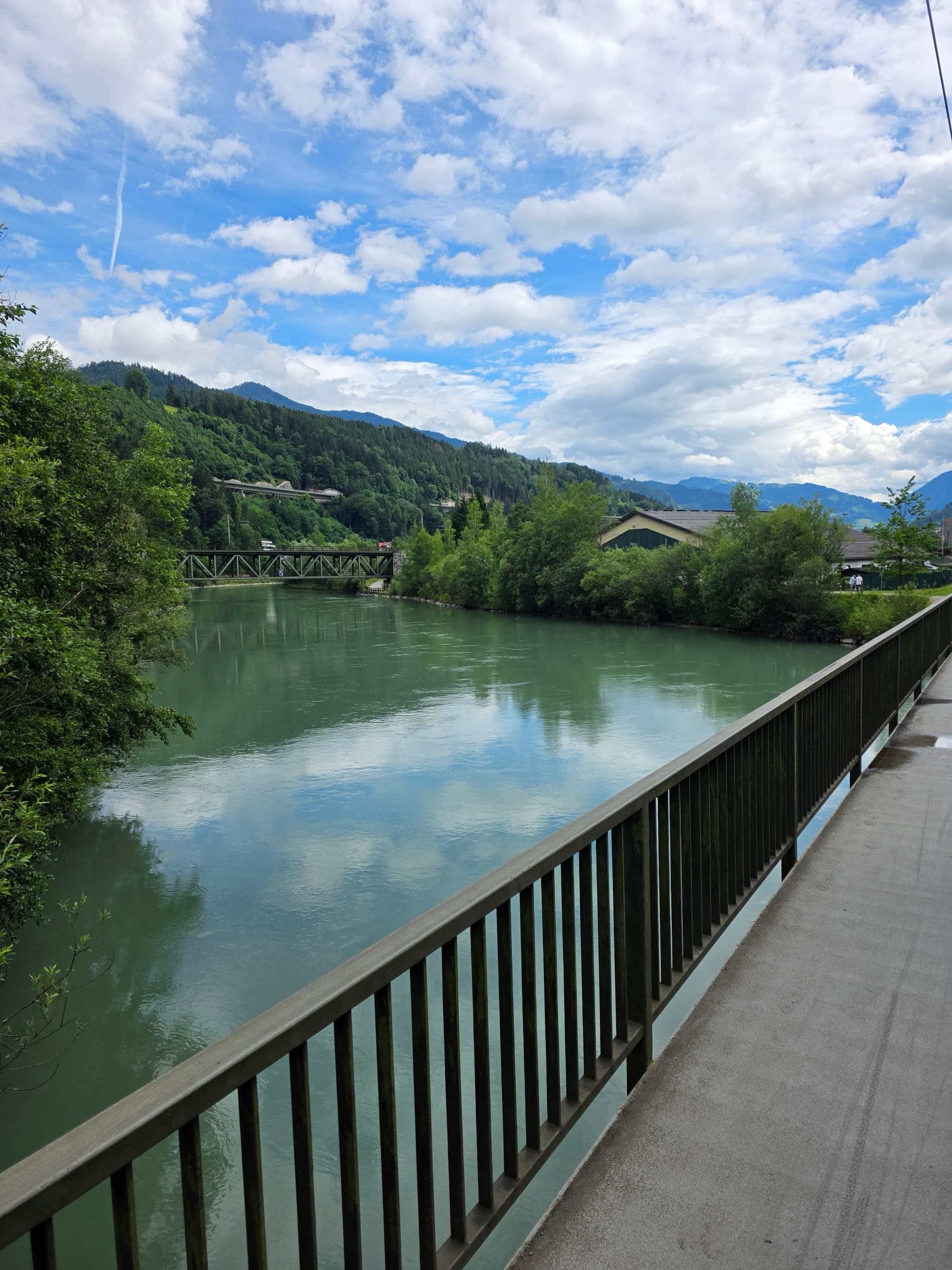 Salzach River viewed from a cycle bridge with mountains and green forests