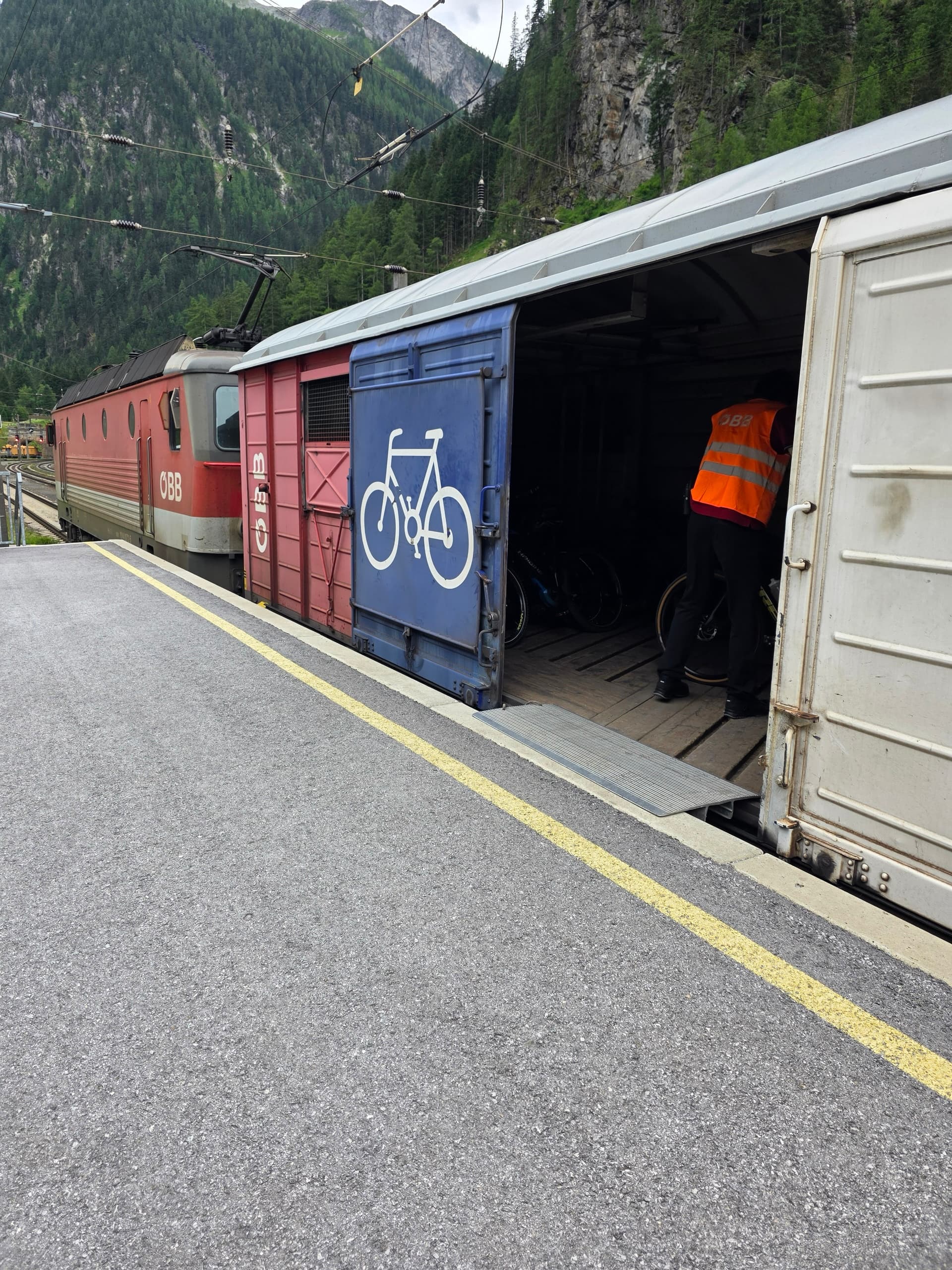 Bicycles being loaded into an alpine rail shuttle train car at a station platform
