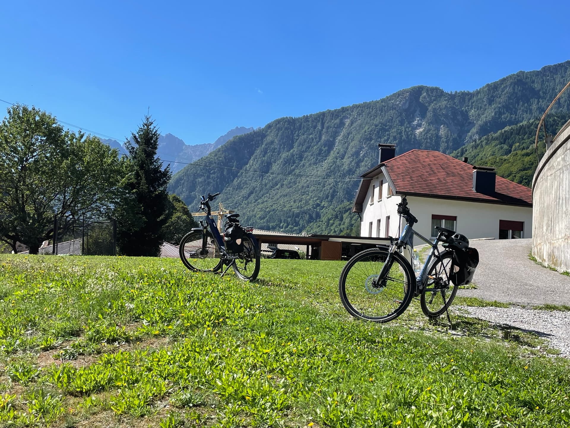 Bicycles parked on grassy field near old station and mountains