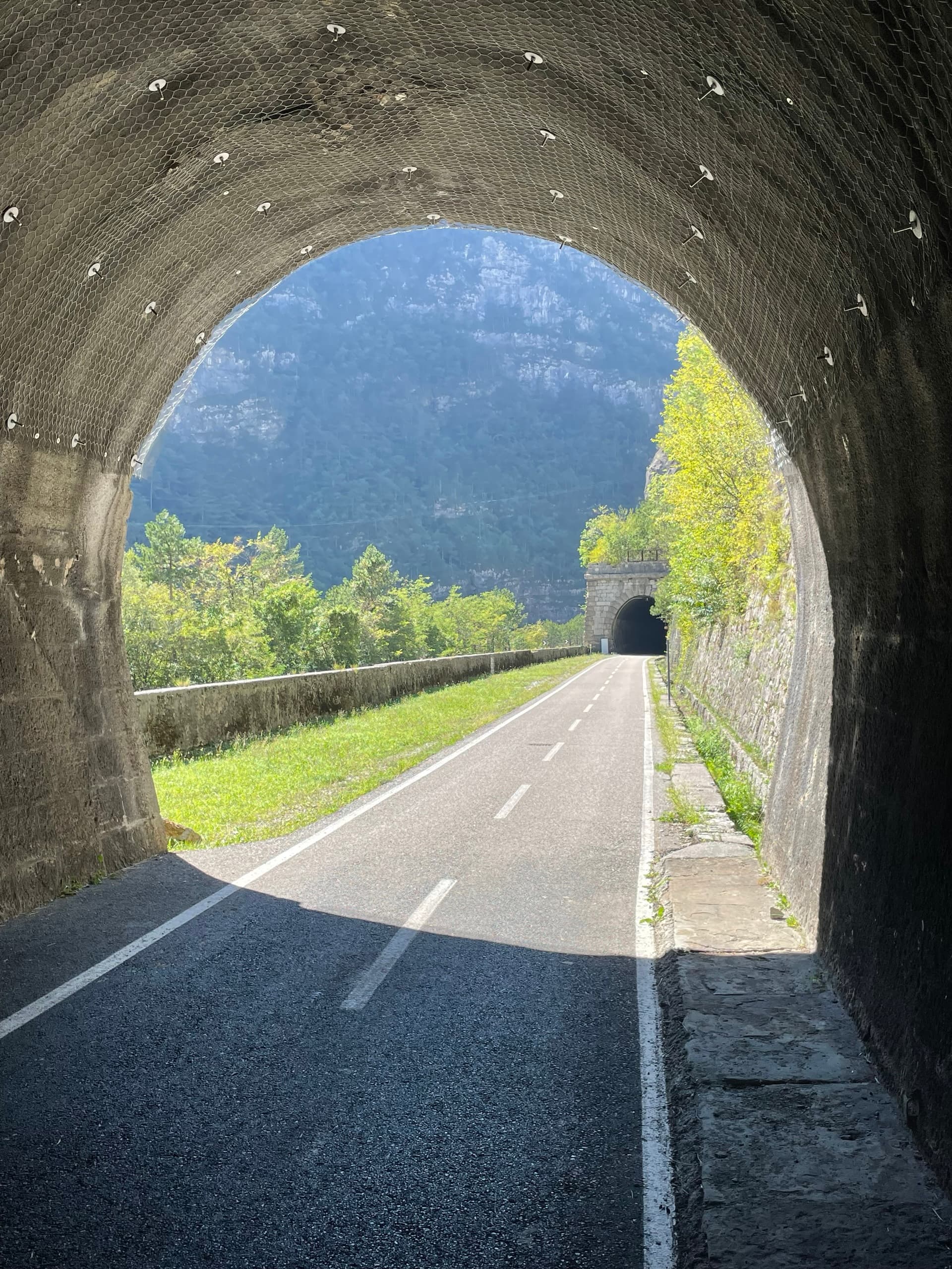 Cycle path through mountain tunnel with surrounding landscape view