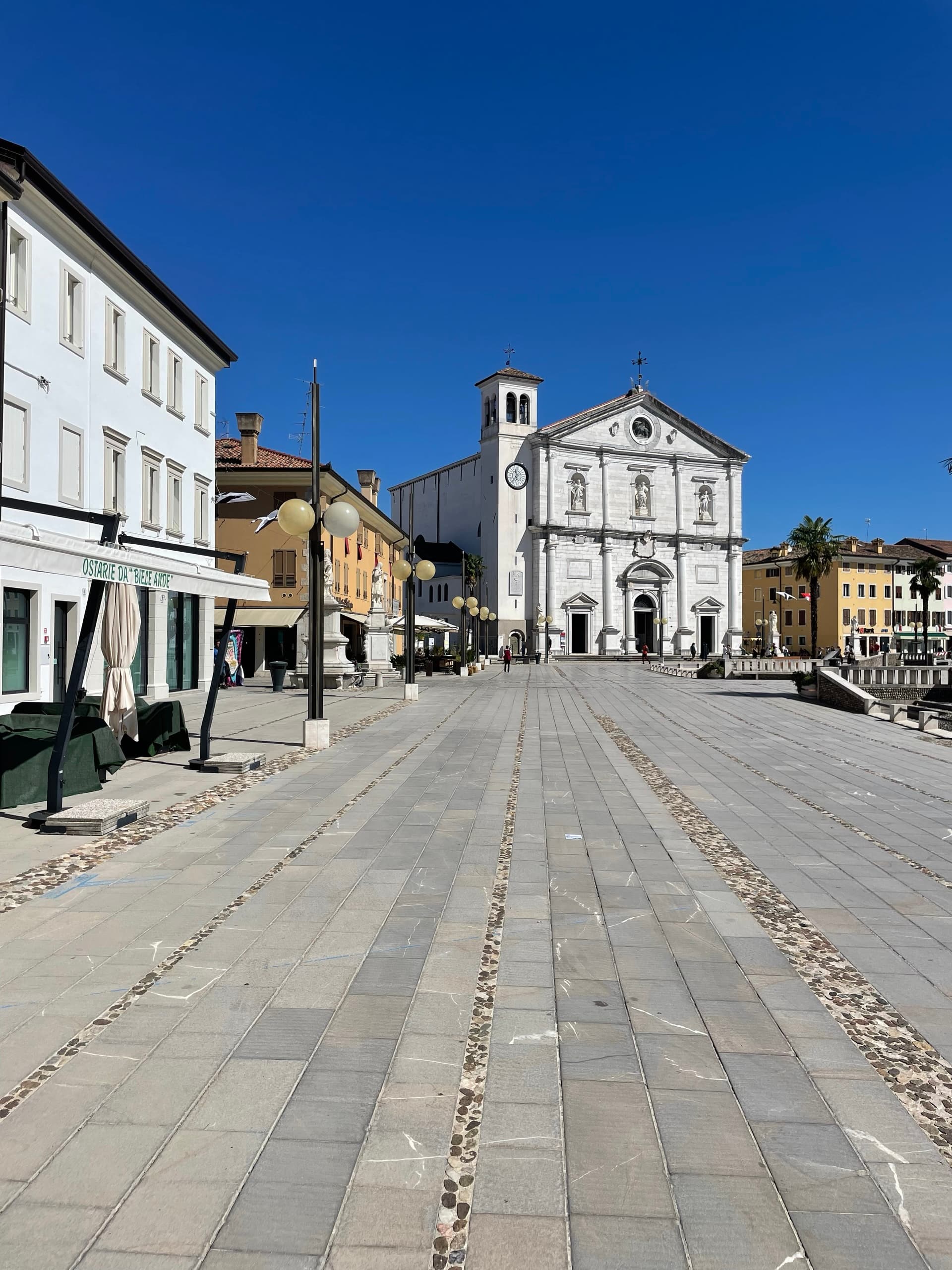 Palmanova main square with cathedral and historic buildings under clear blue sky