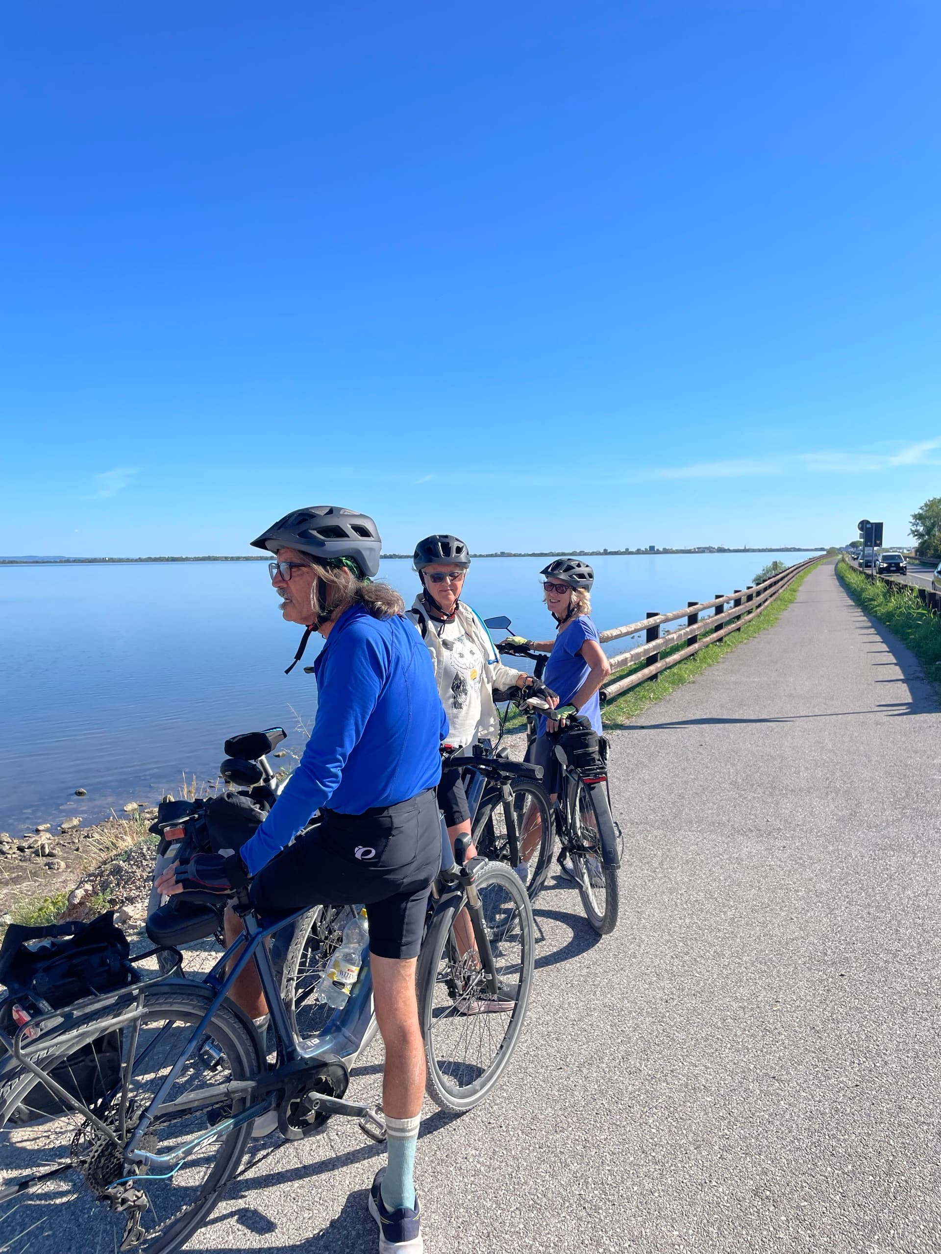 Cyclists on the causeway to Grado along a coastal path by the lagoon.