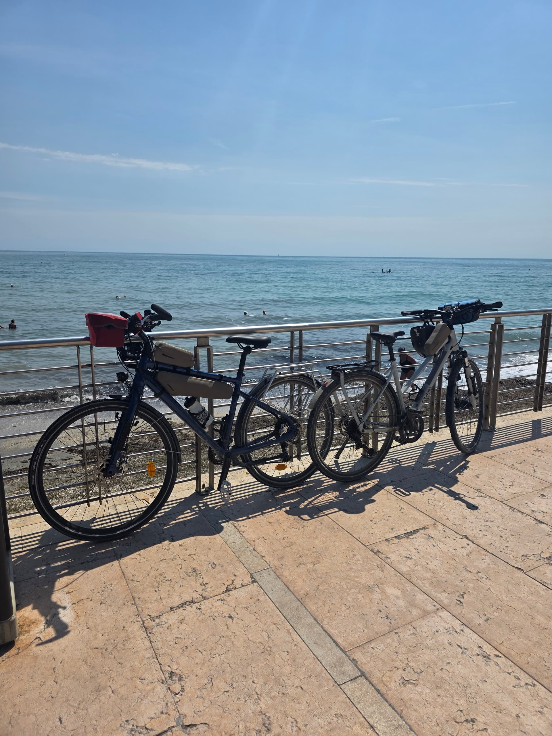 Bikes parked along coastal railing in Grado with sea view