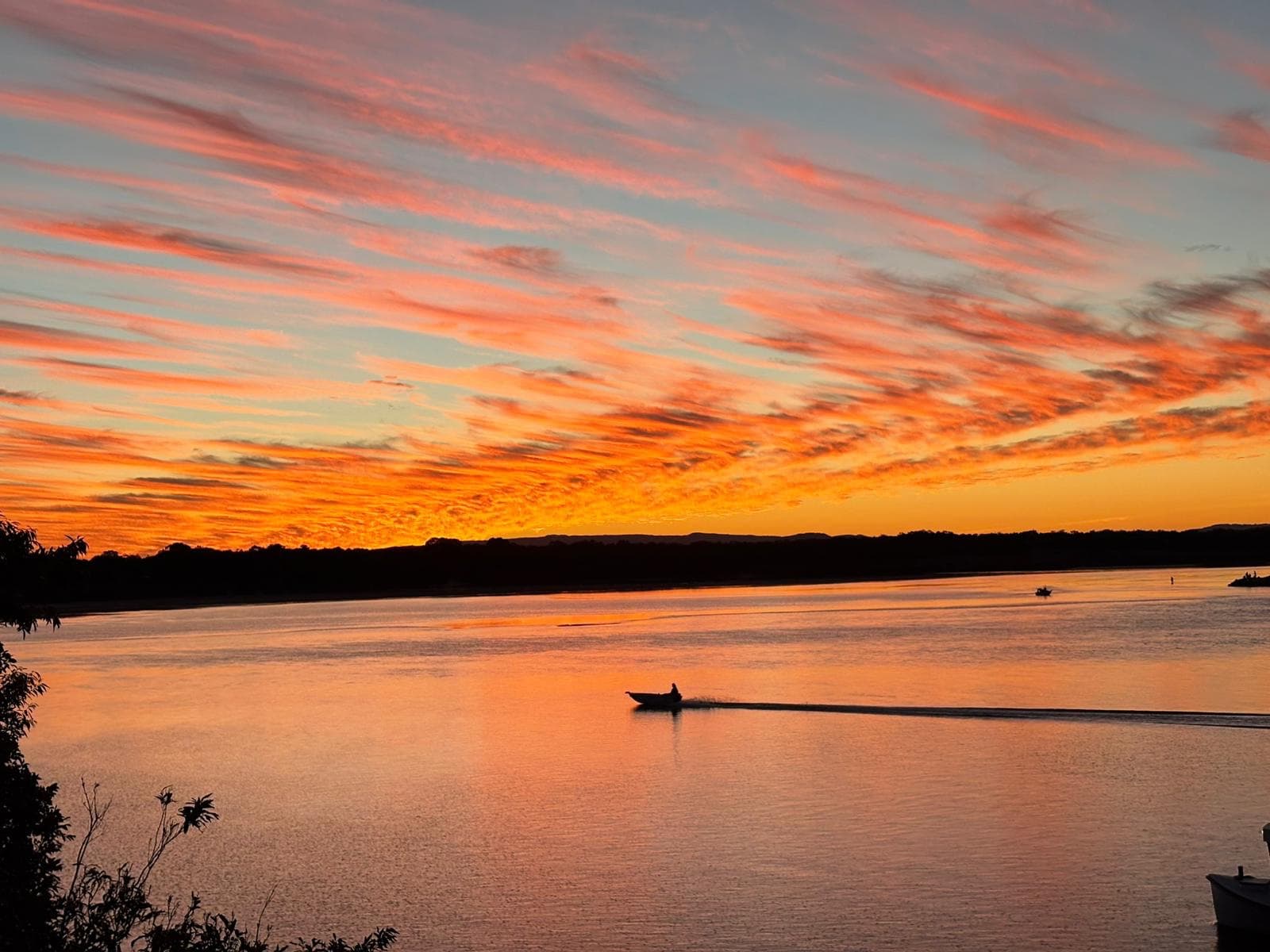 Boat on the Danube river during a vibrant sunset with pink and orange clouds