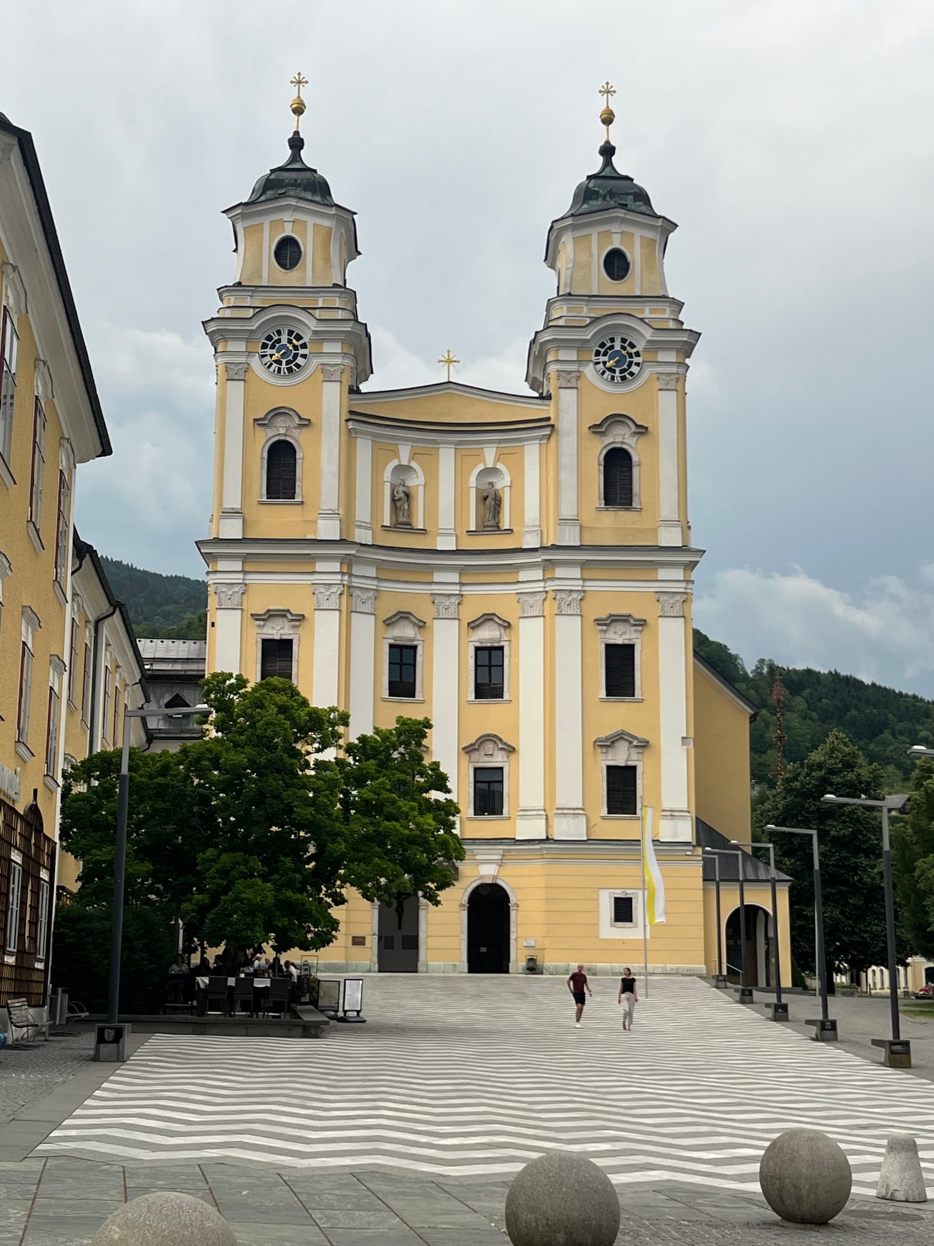 Mondsee Basilica twin towers and yellow facade in town square