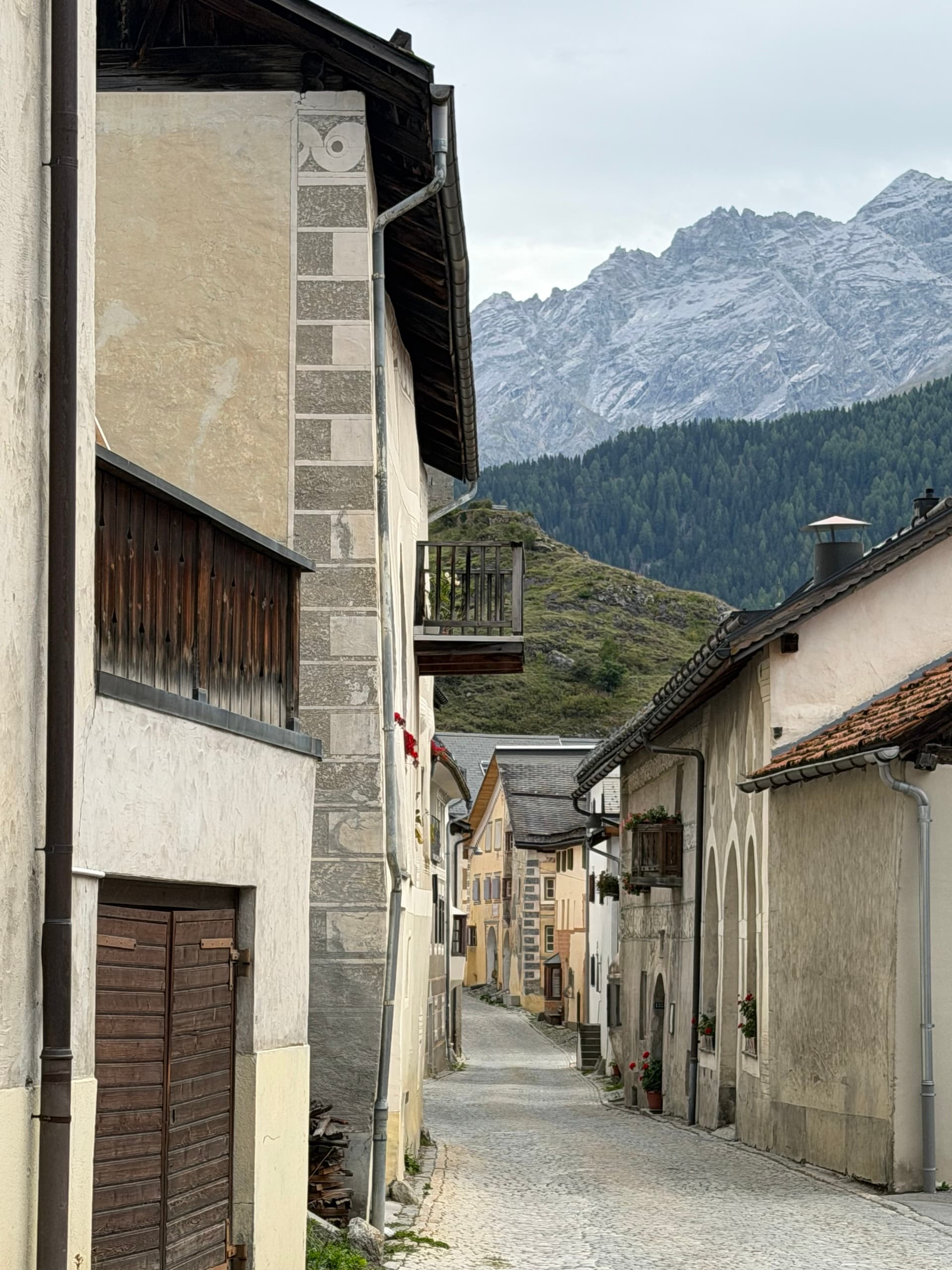 Engadin village lane with traditional houses and alpine mountain backdrop