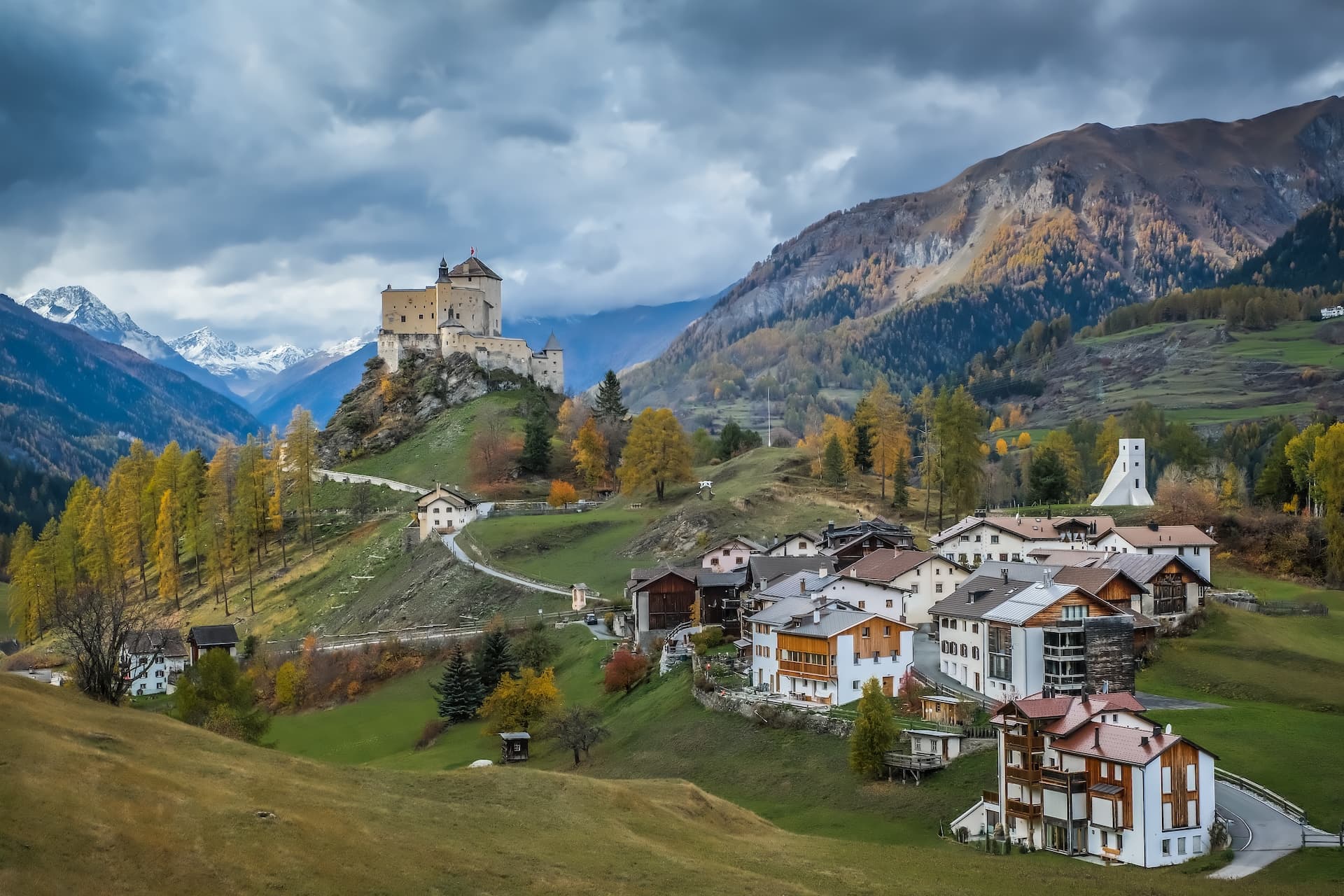 Golden larches surround Castel of Tarasp above Scuol village in the Engadin Alps.