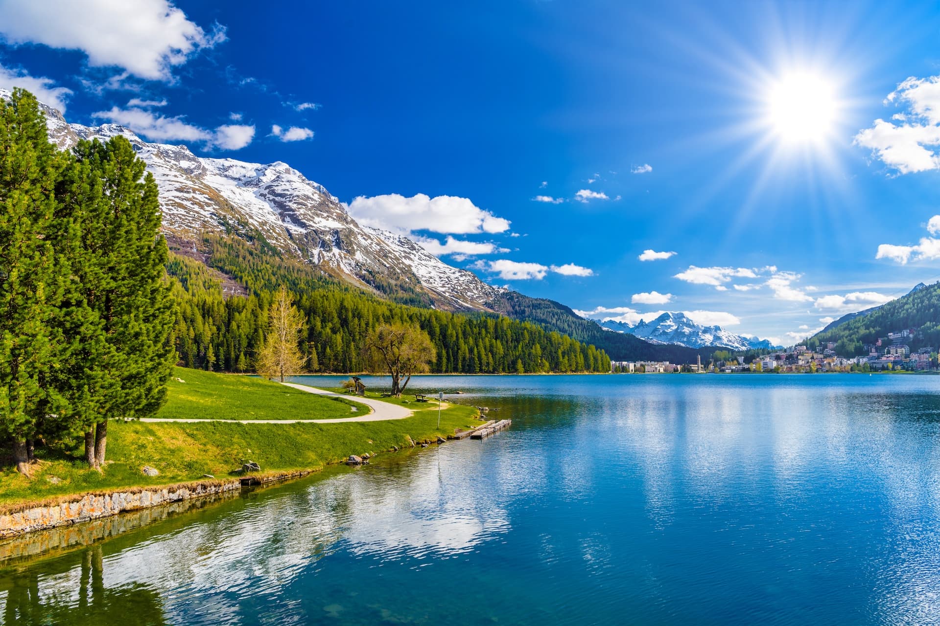 Crystal blue Lake St. Moritz with snow-capped mountains and sunny sky, Grisons, Switzerland.
