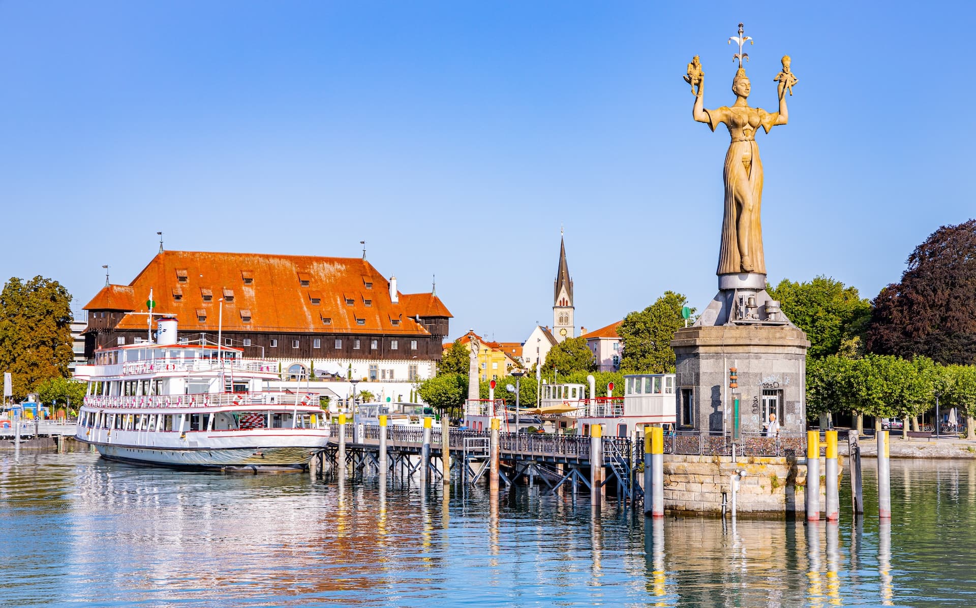 Imperia statue and passenger boat docked at harbor in Konstanz am Bodensee.
